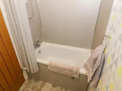a bathroom with a white tub and a shower at Tarnacrye in Annan