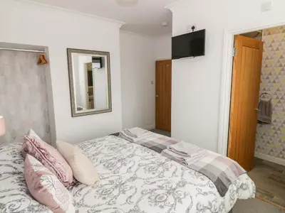 a bedroom with a bed and a mirror and a television at Tarnacrye in Annan
