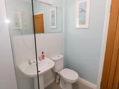 a white bathroom with a toilet and a sink at Tarnacrye in Annan