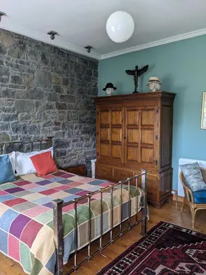 a bedroom with a bed and a brick wall at Kirkview House in Moffat