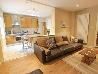 a living room with a couch and a kitchen at The Coach House in Newton Stewart