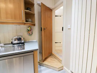 a kitchen with a door leading into a hallway at The Coach House in Newton Stewart