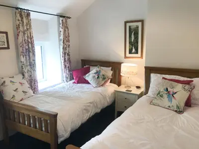 a bedroom with two beds and a window at Garden Cottage in Threlkeld