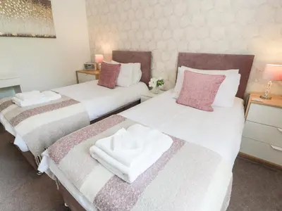 two beds sitting next to each other in a bedroom at Simply Suite in Castle Douglas