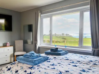 a bedroom with a bed with blue towels on it at Dinduff Lodge in Challoch