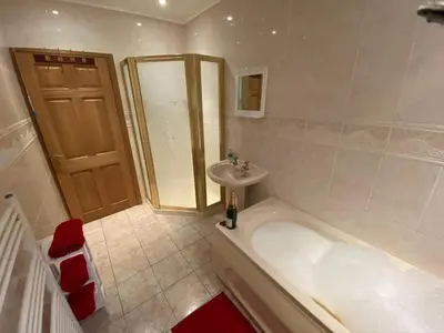 a bathroom with a tub and a sink at Country Cottage Sleeps 6 w Hot Tub & Dog-Friendly in Moniaive
