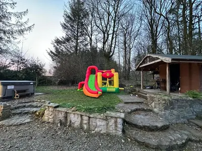 a playground with a slide in a yard at Country Cottage Sleeps 6 w Hot Tub & Dog-Friendly in Moniaive