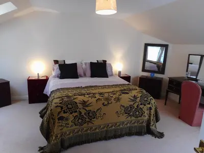 a bedroom with a large bed and two lamps at DairyCottage, 5, TELFORD MEWS BEATTOCK in Moffat