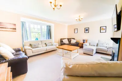 a living room with couches and a table at Briarwood House in Keswick