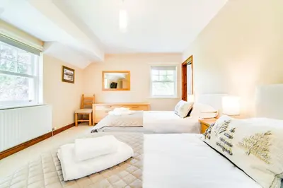 a bedroom with two beds and a couch at Briarwood House in Keswick