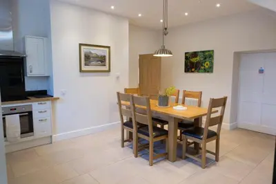 a kitchen with a wooden table and chairs in a room at Netherby Hall in Carlisle