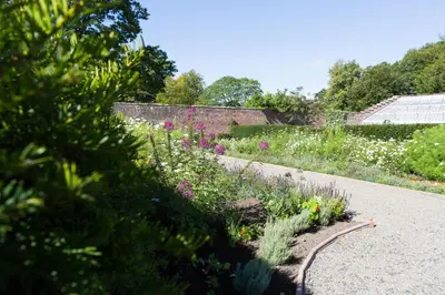 a garden with colorful flowers and a pathway at Netherby Hall in Carlisle