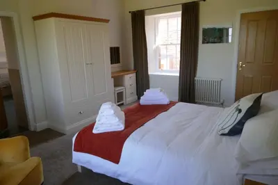 a bedroom with a large bed with towels on it at Netherby Hall in Carlisle