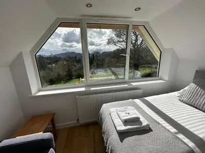 a bedroom with a bed and a large window at Borrowdale View in Keswick