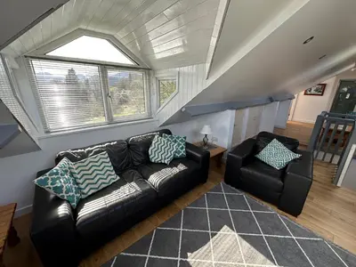 a living room with a leather couch and a chair at Borrowdale View in Keswick