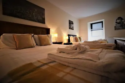 a bedroom with two beds with towels on them at Signature - Kirkhill House in Kirkmuirhill