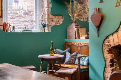 a dining room with green walls and a table at Tithe Barn - Self Check In Hotel in Cockermouth