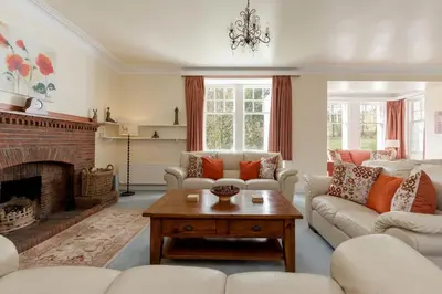 a living room with white furniture and a fireplace at Balcraig House in Maybole