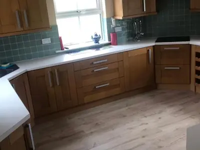 a kitchen with wooden cabinets and a wooden floor at Cumnock Knowes Holiday Retreat in Carsphairn