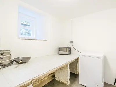 a kitchen with a counter and a refrigerator at Branthwaite Cottage in Caldbeck