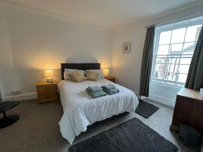 a bedroom with a bed with two towels on it at Stylish 2nd Floor Georgian 1 Bedroom Apartment in Dumfries