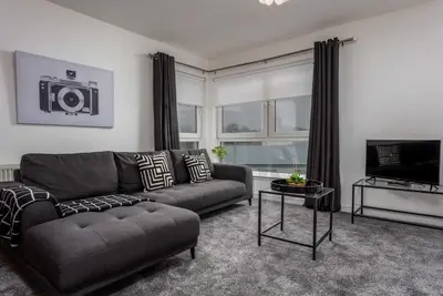 a living room with a couch and a television at Walker Suite No73 - Donnini Apartments in Kilmarnock