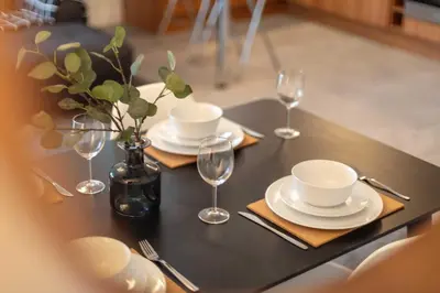 a black table with plates and wine glasses on it at Walker Suite No73 - Donnini Apartments in Kilmarnock