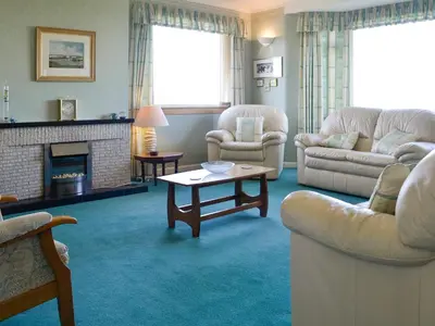 a living room with two couches and a fireplace at Bel-Mar in Whithorn