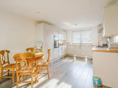 a kitchen with a table and chairs and a kitchen with white cabinets at Seacote Gardens in St Bees