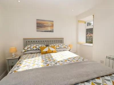 a bedroom with a bed with a yellow bow on it at Old Kiln Cottage in Dumfries