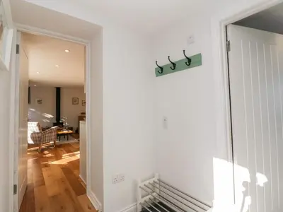 a hallway with a door to a living room at Old Kiln Cottage in Dumfries