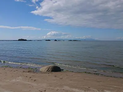 a rock sitting on the beach next to the water at Honesty Cottage in Girvan