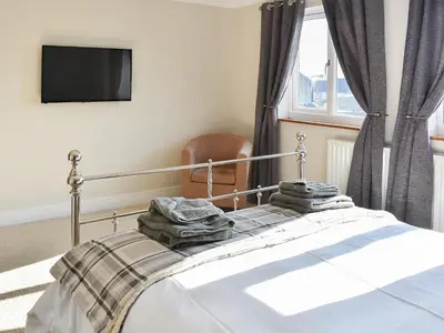 a bedroom with a bed with towels on it at Chapel House in Dearham