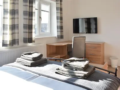 a bedroom with a bed with towels and a desk at Chapel House in Dearham
