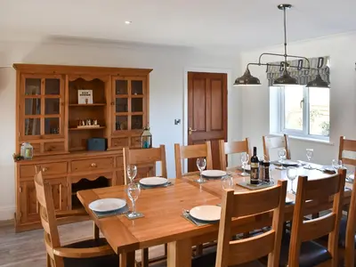 a dining room with a wooden table and chairs at Chapel House in Dearham