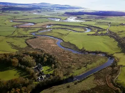 an aerial view of a river and fields at West Lodge - Uk7137 in Newton Stewart