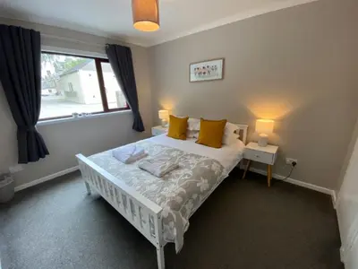 a bedroom with a bed with yellow pillows and a window at West Lodge - Uk7137 in Newton Stewart