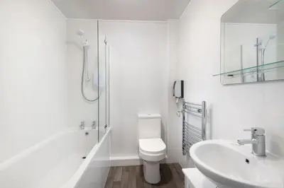 a white bathroom with a toilet and a sink at Four Oaks House in Carlisle