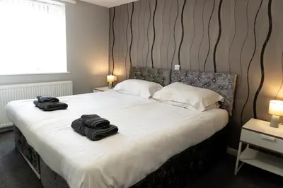 a bedroom with a bed with two towels on it at Four Oaks House in Carlisle