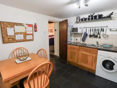 a kitchen with a table and a washing machine at Kiln How in Keswick