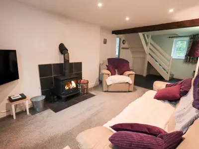 a living room with a couch and a fireplace at Kiln How in Keswick