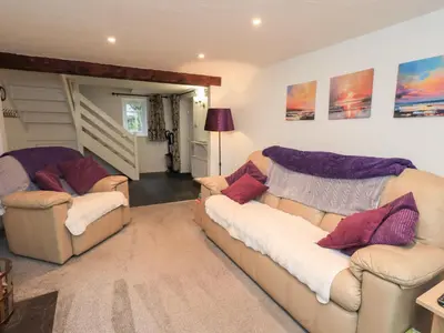 a living room with two couches and a table at Kiln How in Keswick
