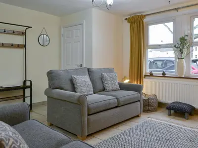 a living room with a couch and a chair at Holly Cottage in Cockermouth