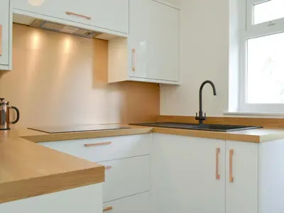 a kitchen with white cabinets and a sink at Langdale Cottage in Chapel Stile