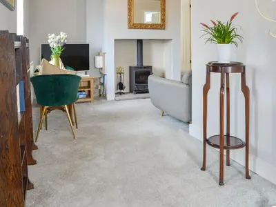 a living room with a couch and a fireplace at Old Reading Room in Cotehill