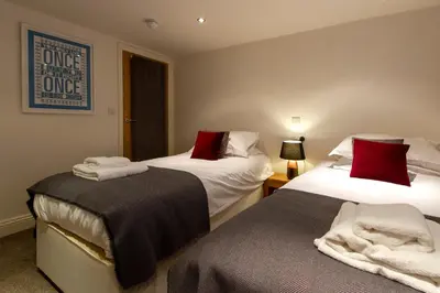 a bedroom with two beds with red pillows at The Lookout Keswick in Keswick