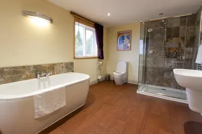 a bathroom with a tub and a sink and a toilet at The Lookout Keswick in Keswick