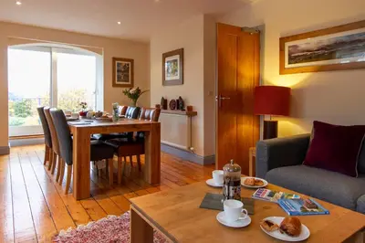 a living room with a table and a couch at The Lookout Keswick in Keswick