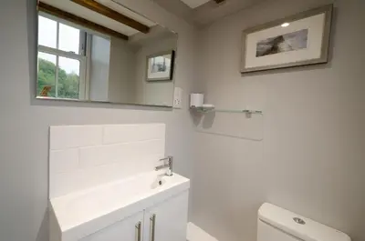 a white bathroom with a sink and a mirror at Cherry Tree Cottage in Chapel Stile