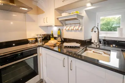 a kitchen with a sink and a stove at Cherry Tree Cottage in Chapel Stile